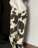 Pantalón cargo de denim color crema con estampado de manchas de vaca marrones.