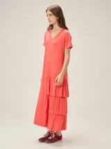 Vestido midi de morley color coral, con escote en V, mangas cortas y falda con tres volados escalonados.