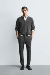 Pantalón de corte slim fit confeccionado en tejido elástico, con cintura elástica, cierre frontal con cremallera y botón, bolsillos laterales y bolsillos traseros de vivo.