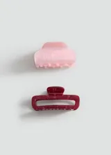 Pack de dos pinzas para el pelo con efecto nacarado y cierre de pinza. Incluye una pinza color rosado claro y otra bordó con diseño rectangular ahuecado.