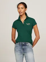 Chomba verde de piqué de algodón elástico, corte slim, con cuello de chomba, cartera de cuatro botones y logo de Tommy Hilfiger bordado en el pecho y en la manga.