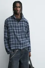 Camisa boxy fit de cuadros en tonos azules y negros, confeccionada en tejido con mezcla de algodón. Cuenta con cuello solapa, manga larga y cierre frontal con cremallera.