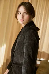 Blazer de terciopelo azul con solapas anchas y cierre frontal de un botón. Presenta un diseño entallado de manga larga con textura suave y acabado ligeramente brillante.