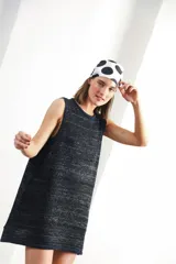 Vestido corto sin mangas, de tejido de punto en color azul marino con efecto jaspeado o tweed en tonos claros. Presenta un corte amplio y relajado, con cuello redondo y bordes en contraste.