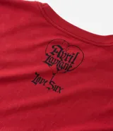 Remera de algodón color rojo con estampado gráfico frontal de Avril Lavigne, globos y letras en estilo gótico.