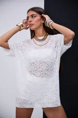 Remerón de encaje blanco con cuello redondo y mangas cortas.