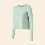 Camiseta deportiva de manga larga color verde menta, con diseño fluido y corte cropped. Presenta cuello redondo y aberturas para los pulgares en los puños.