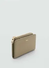 Billetera pequeña de mujer marca Mango, con acabado efecto saffiano en color beige. Cuenta con cierre de botón a presión, múltiples ranuras para tarjetas y un bolsillo exterior con cierre de cremallera. Incluye logo de la marca en relieve en la parte frontal.