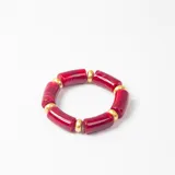 Brazalete elástico compuesto por cuentas cilíndricas de resina en color rojo y esferas metálicas doradas intercaladas.