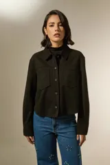 Sobrecamisa de textura gamuzada en color negro, con cuello clásico, cierre frontal de botones y dos bolsillos frontales con solapa.