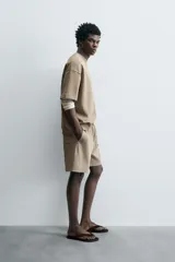 Bermuda de algodón color beige claro, corte relajado (relaxed fit), con cintura elástica ajustable mediante cordón y bolsillos laterales y trasero de plastrón.