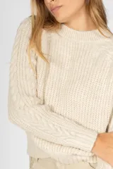 Sweater de tejido de punto con diseño de trenzas en las mangas y cuello redondo. Presenta un corte clásico y puños acanalados.