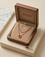 Collar doble de acero dorado compuesto por una cadena de eslabones alargados y una cadena de bolitas con un dije central de dos círculos entrelazados.