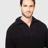Sweater de punto grueso color negro, con cuello alto y cierre frontal parcial metálico. Presenta puños y ruedo acanalados, con un diseño de calce holgado.