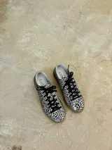 Championes de cuero con estampado animal print en blanco y negro, cordones negros y suela de goma color caramelo.