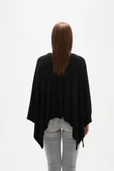 Poncho negro de tejido de punto con escote en V, diseño asimétrico y corte holgado.