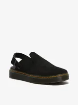 Zueco negro de gamuza con suela plana y correa ajustable en el talón.