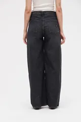 Jean de corte amplio y holgado, con diseño de pierna ancha y tiro medio. Presenta un acabado lavado en tono gris oscuro.