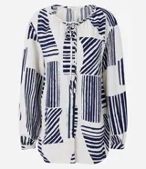 Camisa amplia de viscolino con estampado geométrico en azul marino sobre fondo crudo. Tiene cuello redondo con lazo, mangas largas abullonadas y abotonadura frontal.