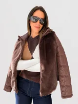 Campera con cuerpo de piel sintética tipo teddy y mangas acolchadas. Presenta cierre frontal, capucha y diseño de corte recto.