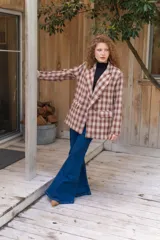 Jeans de corte flare color azul oscuro, tiro alto y diseño ajustado en las piernas que se ensancha gradualmente desde las rodillas hacia el dobladillo.