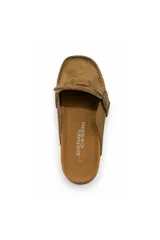 Zueco estilo mocasín negro con acabado efecto gamuza, detalle de hebilla metálica lateral y costuras visibles en el contorno. Cuenta con plantilla anatómica y suela baja.
