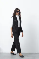 Chaleco de estilo utilitario color bordó con pespuntes blancos a contratono. Presenta solapas, cierre frontal con botones, bolsillos delanteros y un diseño estructurado.