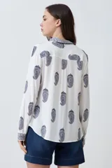 Camisa de manga larga color blanco con estampado de arabescos en azul marino.