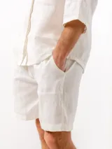 Shorts de lino color blanco, con cintura elástica, dos bolsillos laterales y un bolsillo trasero.