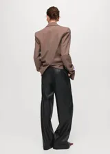 Pantalon de tiro medio efecto piel con diseño wide leg, bolsillos laterales, pinzas delanteras y cierre frontal de botón, gancho y cremallera ocultos.