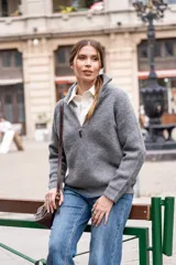 Cárdigan gris de tejido de punto acanalado, con cuello alto, cierre de cremallera corto y corte holgado.