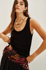 Top sin mangas de tejido de punto fino en color negro, con escote redondo y corte ajustado al cuerpo.