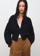 Pantalón de vestir color marrón, de corte amplio y fluido, con tiro alto y diseño recto de perneras anchas.