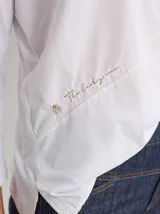 Remera blanca de algodón con corte holgado y costuras a la vista en color beige.