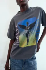 Camiseta de algodón gris oscuro con efecto lavado, corte oversize y manga corta. Presenta un estampado frontal con la ilustración del álbum "In Utero" de Nirvana, con la palabra "NIRVANA" en vertical a la izquierda y "IN UTERO" a la derecha.