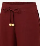 Pantalón de corte recto confeccionado en mezcla de viscosa y lino. Presenta cintura elástica con cordón ajustable y bolsillos laterales.