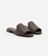 Sandalia plana Beira Rio de diseño minimalista, confeccionada en material sintético color marrón, con tira ancha sobre el empeine y taco bajo cuadrado.