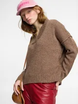 Sweater de tejido de punto color ladrillo. Escote en v y mangas largas de sisa caída. Confeccionado en lana.