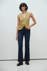 Pantalón de jeans azul oscuro, corte bootcut, tiro medio y calce slim desde la cintura hasta la rodilla.