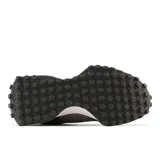 Championes New Balance modelo 327 para mujer, en tonos de gris oscuro y negro. Presentan una combinación de materiales como ante y malla, con el logo 'N' grande y asimétrico en textura de gamuza. La suela es de cuña ensanchada con relieve inspirado en zapatillas de trail.