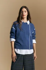 Sweater de punto color marrón con diseño de líneas blancas en contraste. Presenta cuello redondo, mangas largas y puños tejidos, con una estética minimalista y moderna.