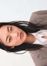 Blazer de corte recto y silueta estructurada, con cuello solapa y cierre frontal de botones. Presenta un diseño de estampado micro-cuadros en tonos tierra.