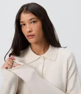 Saco de tricot negro de corte regular, con cuello polo, mangas largas y cierre frontal con botones. Presenta un diseño clásico y versátil.
