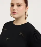 Remera negra de algodón con cuello redondo, mangas cortas abullonadas y apliques flocados con diseño de leopardo.