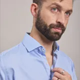 Camisa negra de algodón con cuello clásico, manga larga y cierre frontal con botones. Presenta un logo bordado en el pecho. Corte entallado.