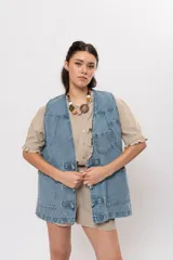 Chaleco de denim azul con bolsillos frontales aplicados y cierre con trabillas y botones frogs.