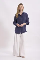 Camisa de manga larga, color azul marino, con cuello camisero y corte holgado.