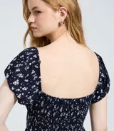 Vestido midi de viscosa con estampado floral liberty, escote recto, mangas cortas abullonadas y falda fluida con caída leve.