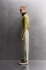 Camiseta térmica de manga larga ranglán, cuello redondo, color verde oliva con efecto tie-dye o jaspeado. Presenta tejido con lana, alta elasticidad y ajuste al cuerpo, con estructuras combinadas para facilitar la transpiración y sin costuras.