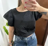 Top negro de nylon con escote redondo y mangas cortas abullonadas con volados, corte holgado.